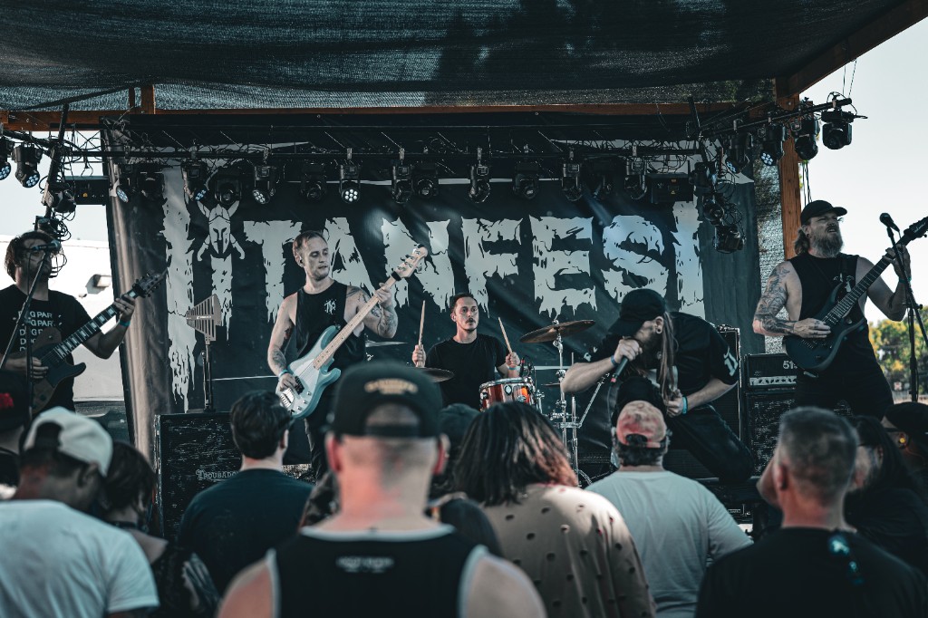 Five-piece band performing live on an outdoor festival stage